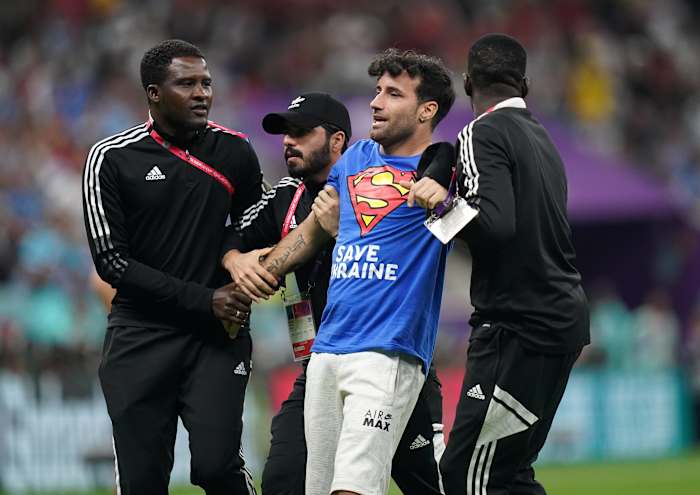 Security staff at Lusail Stadium pictured escorting a pitch invader off the field during a World Cup game between Portugal and Uruguay in November 2022